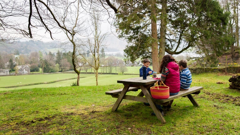 A family enjoy a picnic at Allan Bank and Grasmere, Cumbria